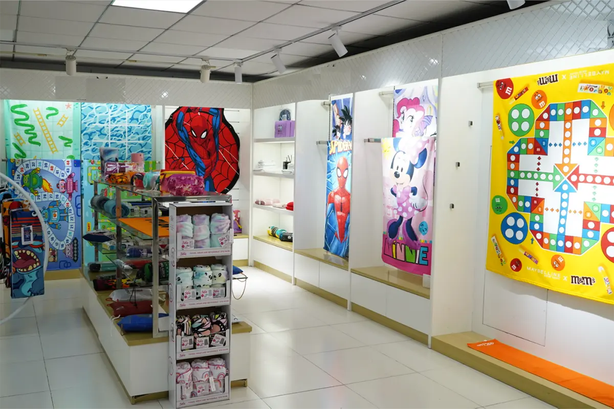 Printed beach towels displayed on showroom walls and sample shelves