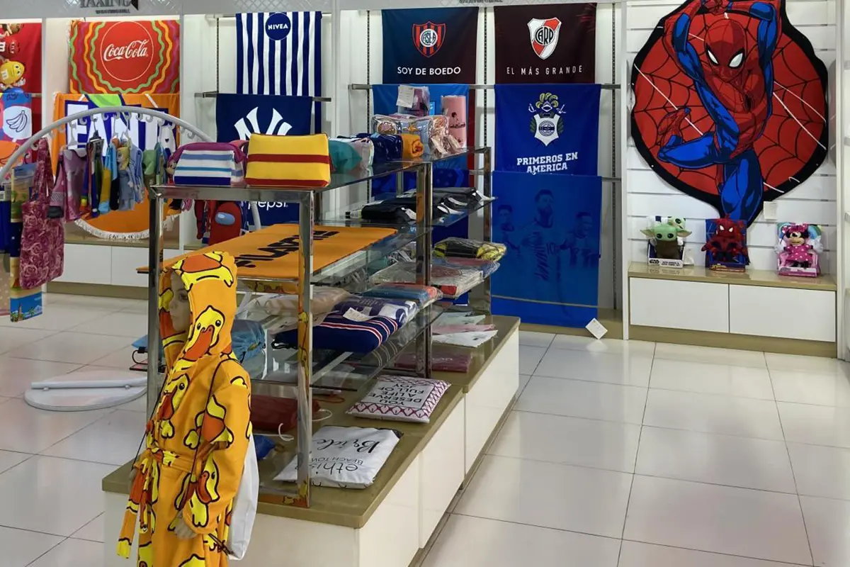 Folded towel samples on showroom shelves beneath hanging designs