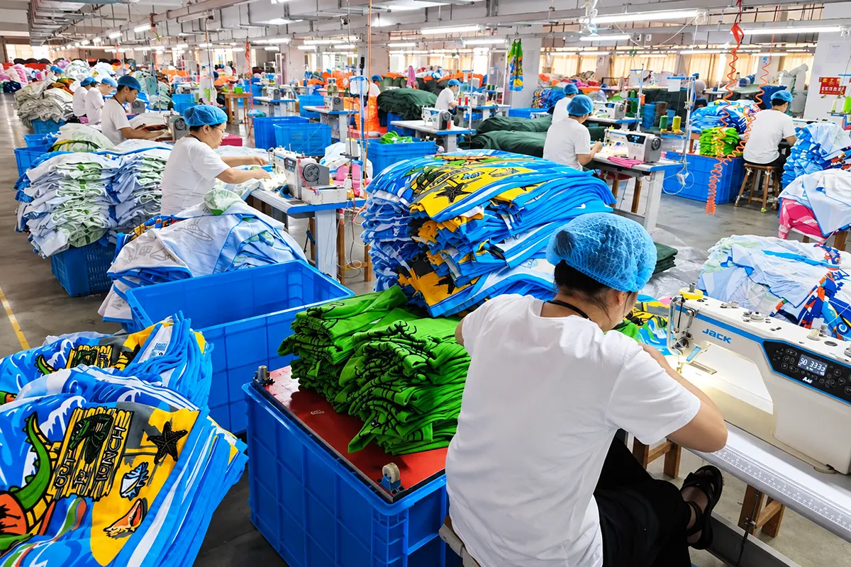 Production team sewing colorful printed towels at individual workstations