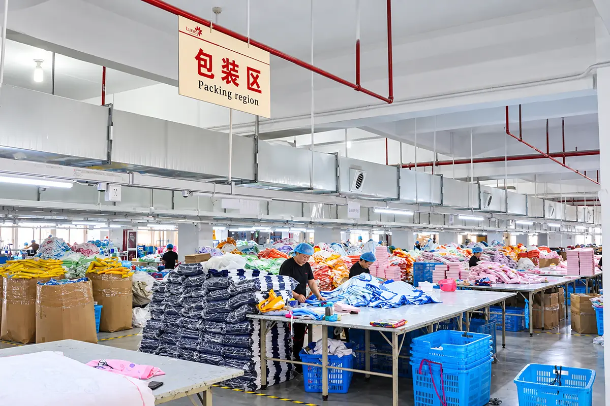 Workers folding and arranging finished towels at packing tables