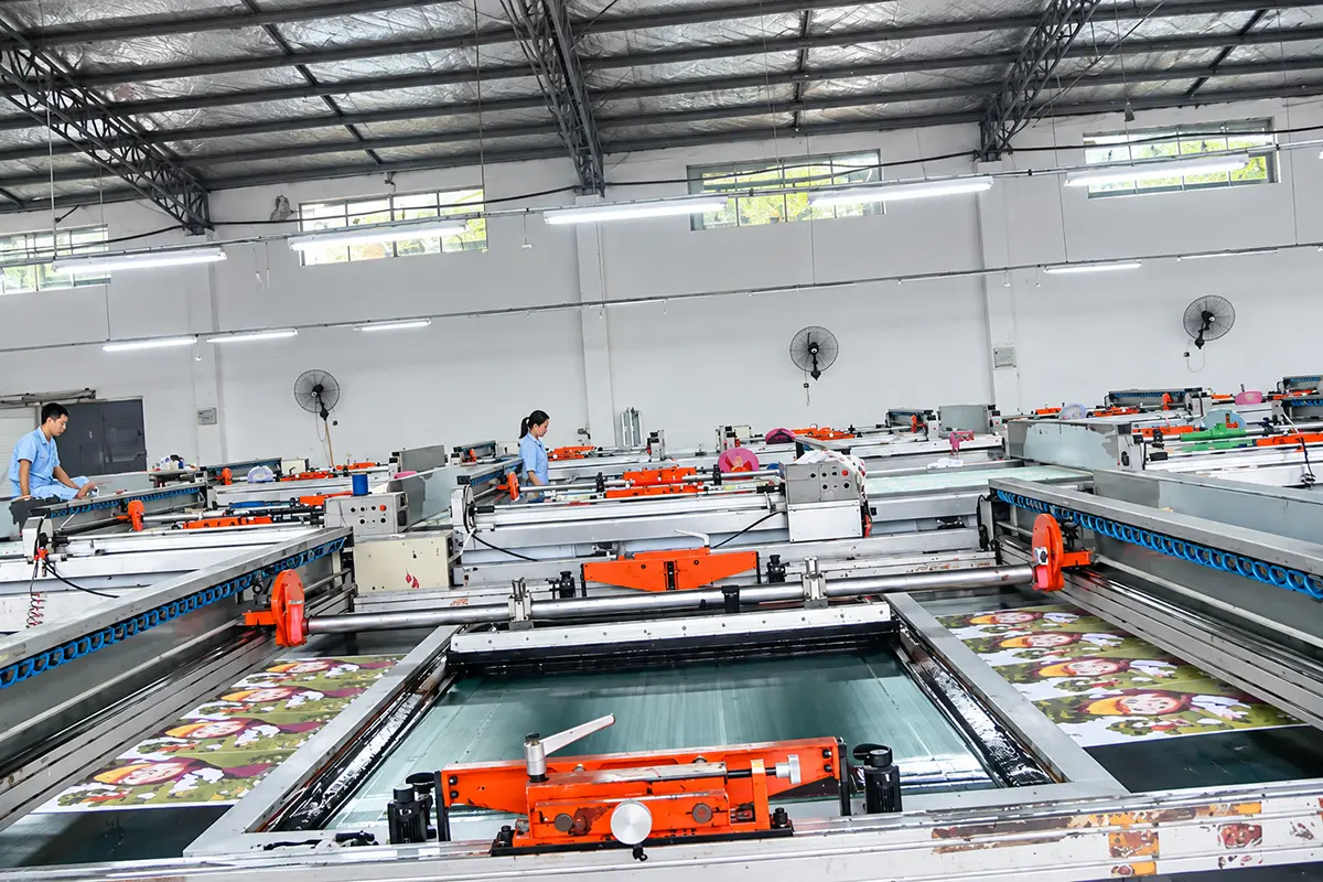 Fabric laid out across screen-printing machines in the production workshop