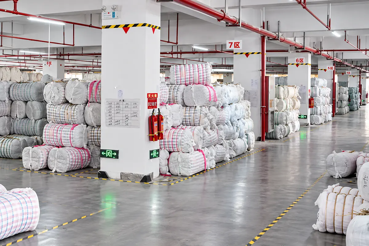 Wrapped fabric bundles grouped in numbered warehouse sections