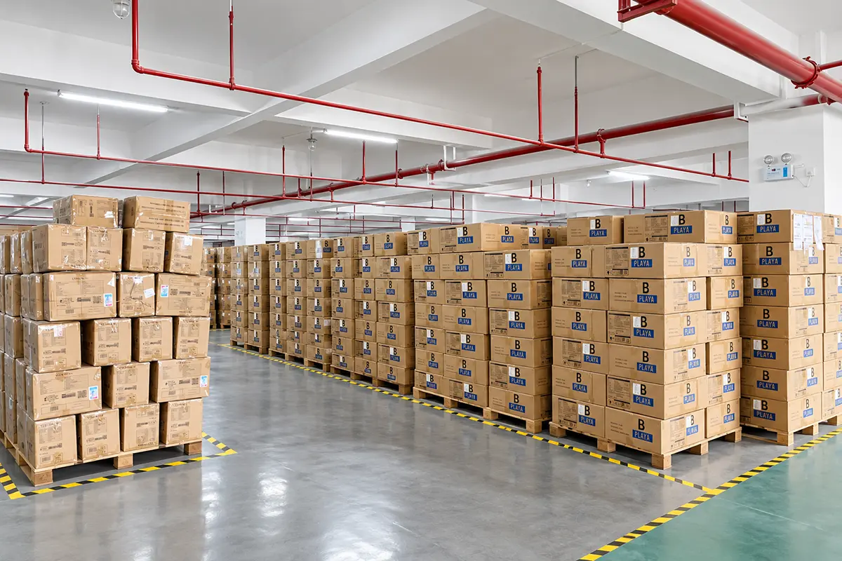 Sealed shipping cartons stacked in a marked warehouse storage area