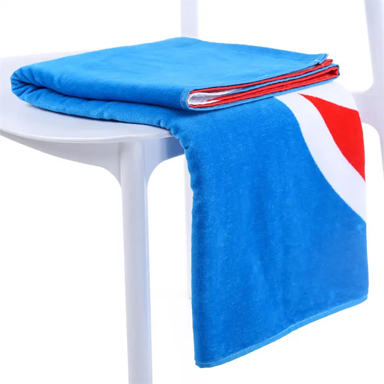 Blue beach towel with red and white color blocks folded over a white chair.
