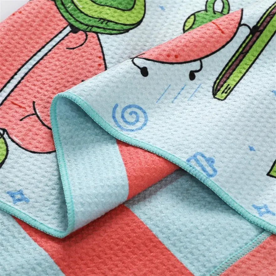 Close-up of the cartoon apple towel showing its textured surface and mint green stitched edging.