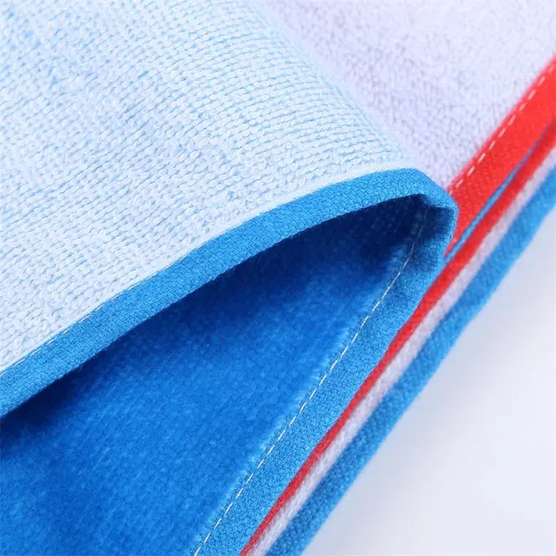 Close-up of a blue stitched towel hem with white loop texture and a red stripe.