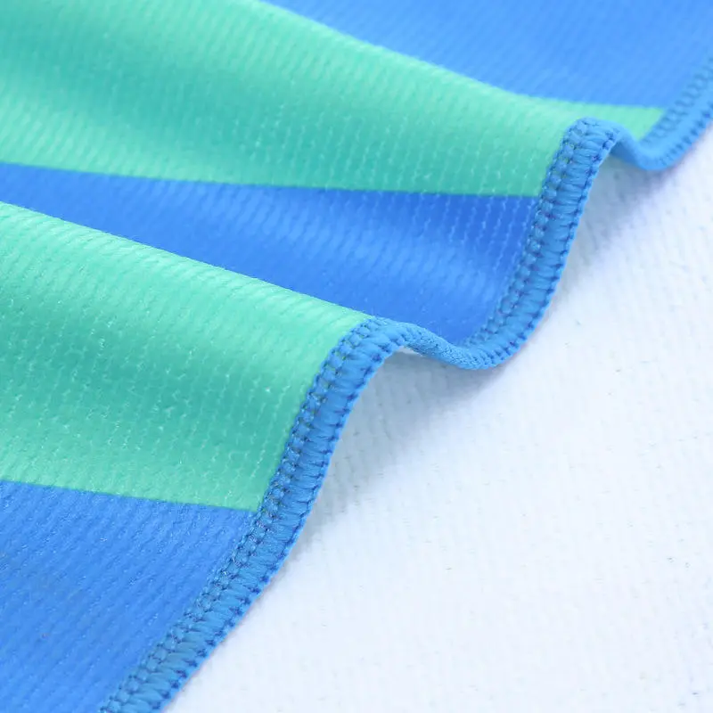 Close-up of blue and aqua towel stripes with blue stitched edging and a white reverse.