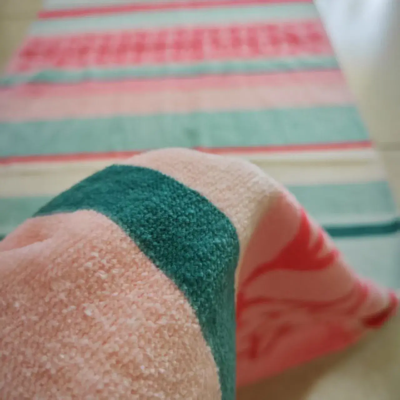Close-up of the textured towel surface with pink and teal stripes.