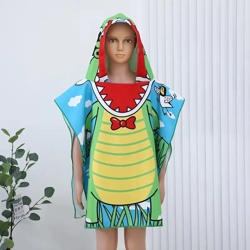 Green cartoon-print hooded beach towel with a red bow tie design displayed on a child-sized mannequin.